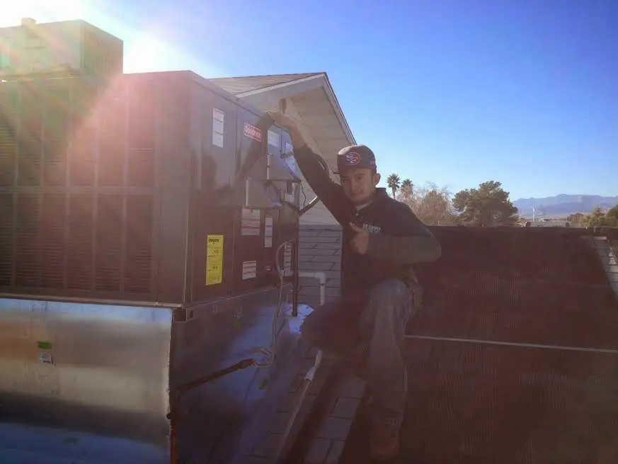 HVAC technician performing Heat Pump Repair on a rooftop unit in Sayreville